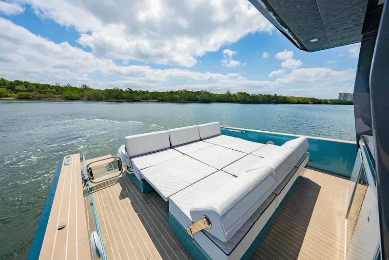 Strade Blu Yacht Photos Pics 2024 Fiart 39 Seawalker yacht with sunbed, cruising on a serene lake under a partly cloudy sky.