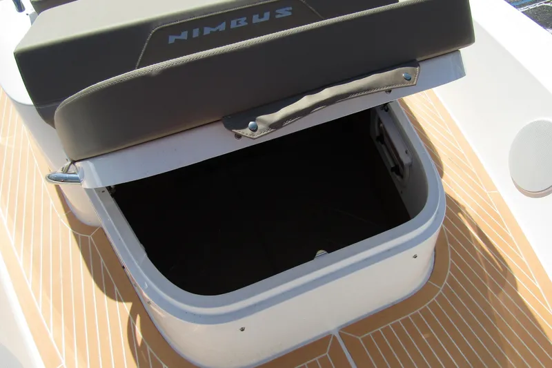  Yacht Photos Pics Open storage compartment on 2025 Nimbus Commuter 11 boat with cushioned seat.