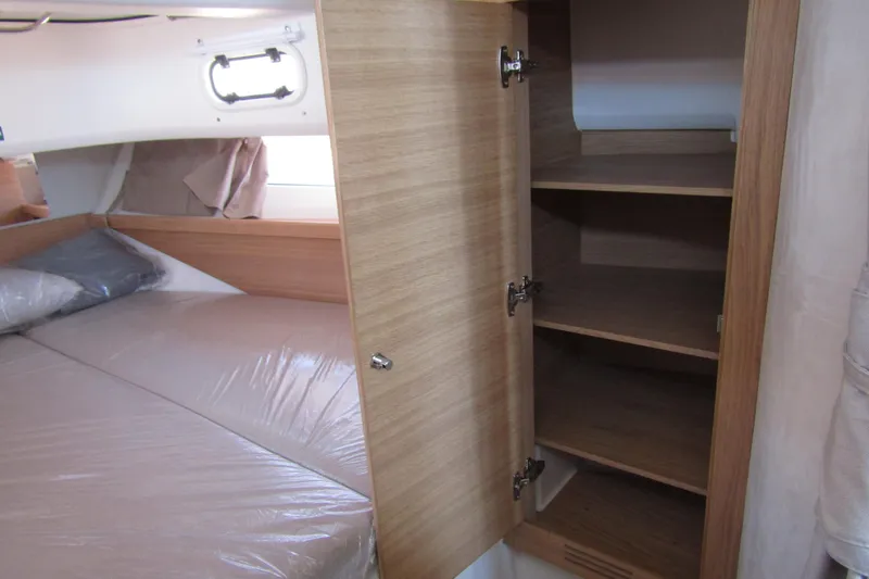  Yacht Photos Pics Cozy cabin interior of 2025 Nimbus Commuter 11 with bed and open wooden storage.