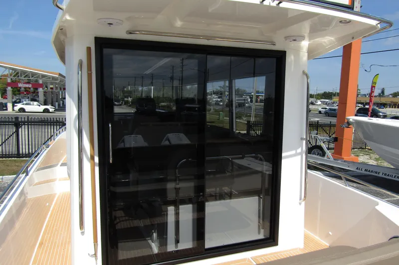 Yacht Photos Pics 2025 Nimbus Commuter 11 boat with sleek glass door and modern design.
