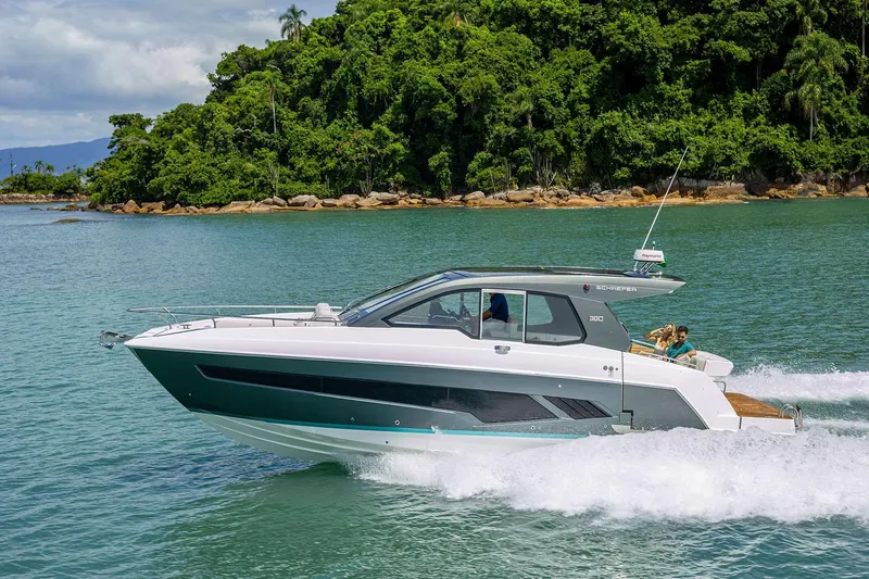  Yacht Photos Pics 2025 Schaefer 380 yacht cruising on tropical waters near lush green island.