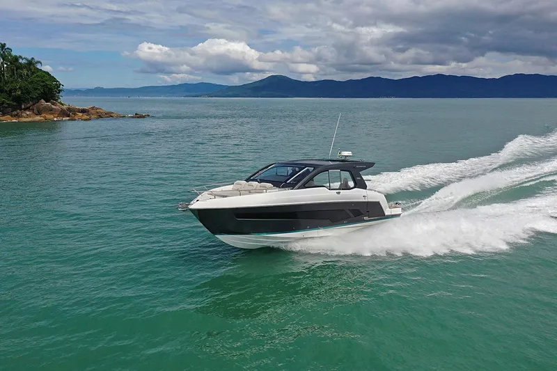  Yacht Photos Pics 2025 Schaefer 380 yacht cruising on turquoise waters under a cloudy sky.