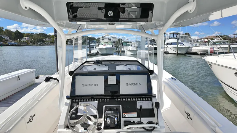  Yacht Photos Pics 2022 Fountain 38TE boat dashboard with Garmin navigation, docked in a marina.