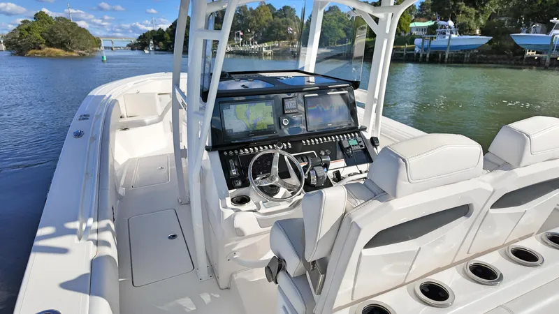  Yacht Photos Pics 2022 Fountain 38TE boat interior with modern dashboard and seating on a scenic waterway.