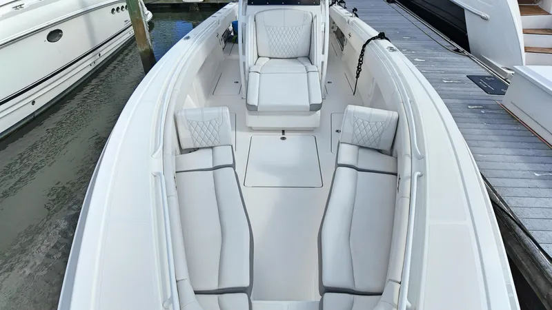  Yacht Photos Pics 2022 Fountain 38TE boat with luxurious white seating docked at marina.