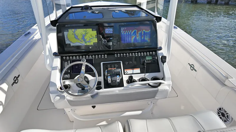  Yacht Photos Pics 2022 Fountain 38TE boat dashboard with navigation screens and controls on water.