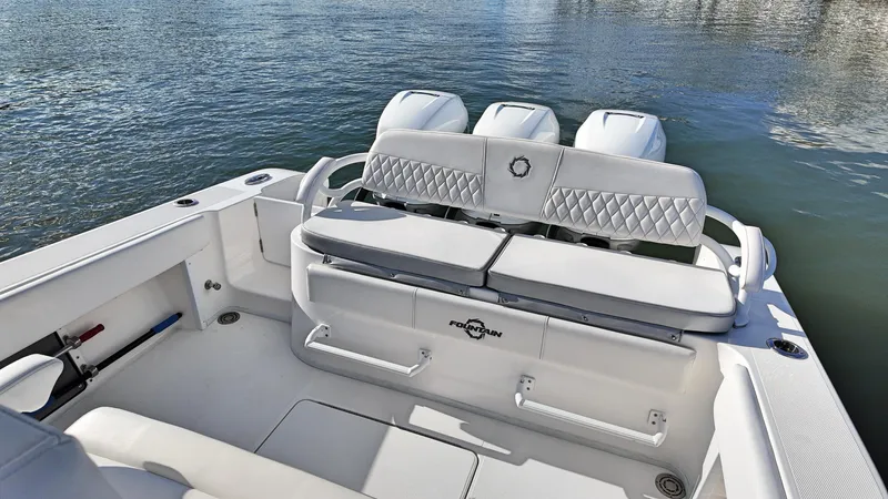  Yacht Photos Pics 2022 Fountain 38TE boat with triple engines, white seating, and diamond stitching on calm water.