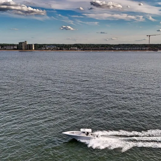  Yacht Photos Pics 2022 Fountain 38TE boat cruising on open water under a partly cloudy sky.