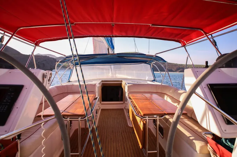 Ayacucho Yacht Photos Pics Cockpit view of 2008 Hanse 630E sailboat with red canopy and wooden seating.