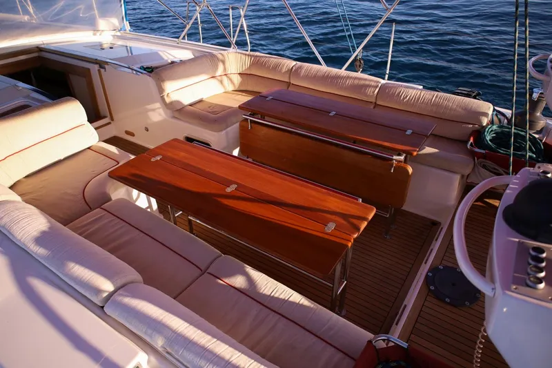 Ayacucho Yacht Photos Pics Luxurious seating area on 2008 Hanse 630E yacht with wooden tables and ocean view.