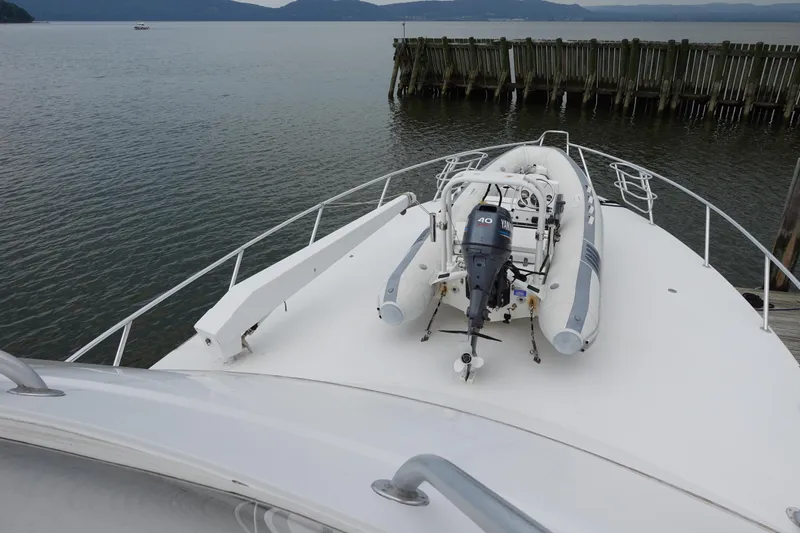  Yacht Photos Pics 1988 Donzi Z-65 Tournament Fisherman yacht with dinghy on deck, docked by wooden pier.