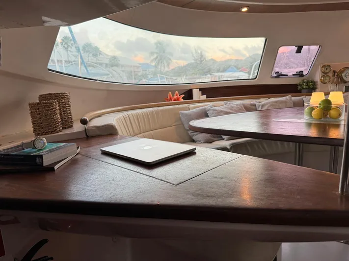 Savannah Yacht Photos Pics Interior of 1998 Fountaine Pajot Bahia 46 catamaran with cozy seating and wooden table.