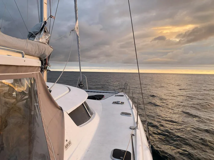 Savannah Yacht Photos Pics Sailing on a 1998 Fountaine Pajot Bahia 46 catamaran at sunset, with cloudy skies.