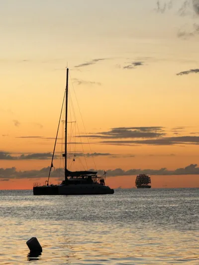 Savannah Yacht Photos Pics Sailing catamaran Fountaine Pajot Bahia 46 at sunset on calm waters, 1998 model.