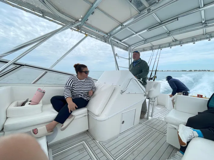  Yacht Photos Pics People relaxing on a 2001 Contender 35 Side Console boat, cruising on open water.