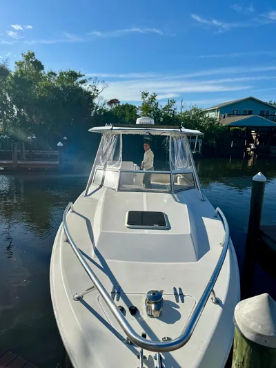  Yacht Photos Pics 2001 Contender 35 Side Console boat docked on a sunny day, surrounded by lush greenery.