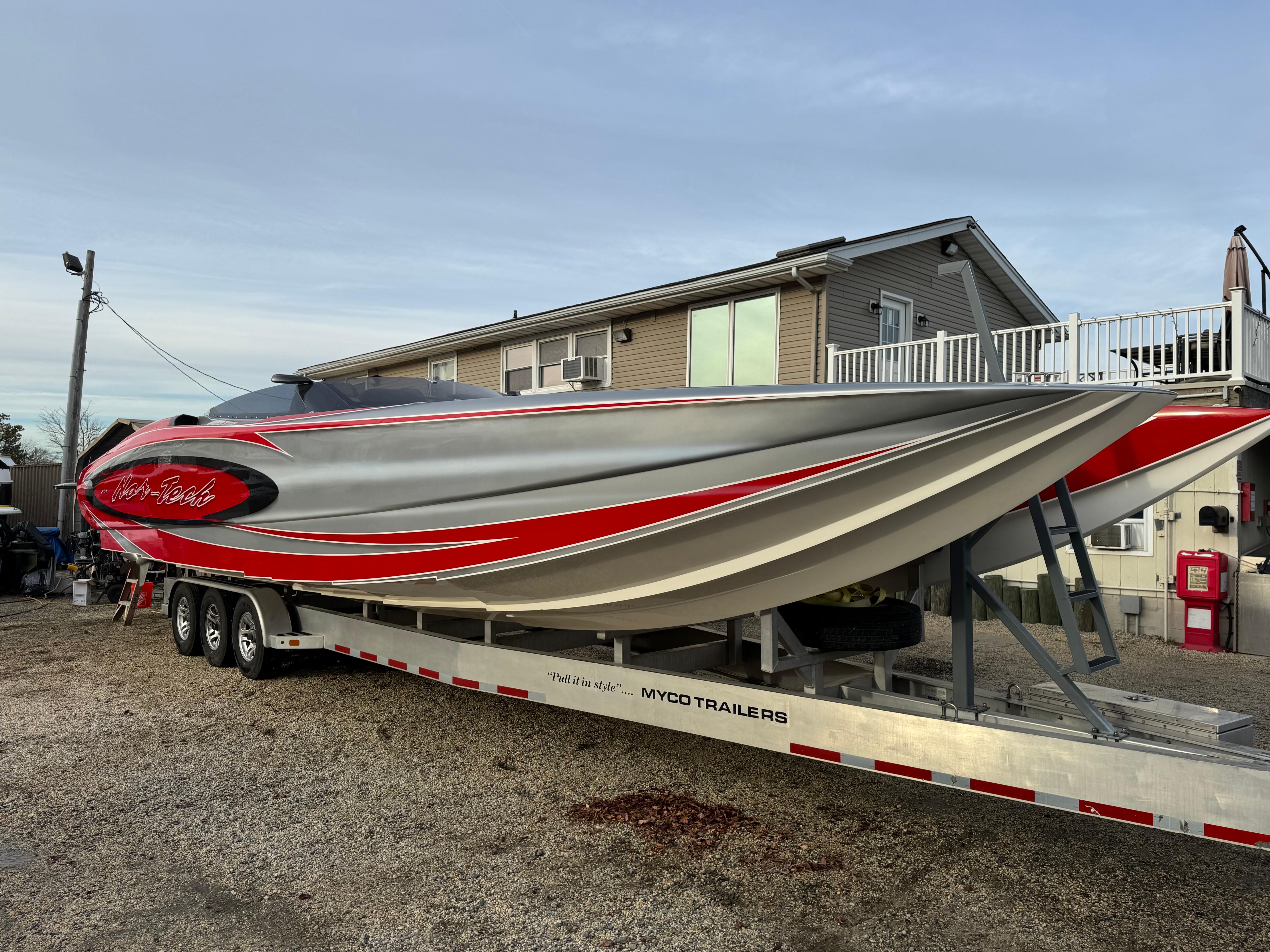 2010 Nor-Tech 4000 Roadster boat on trailer, sleek design with red and gray accents.