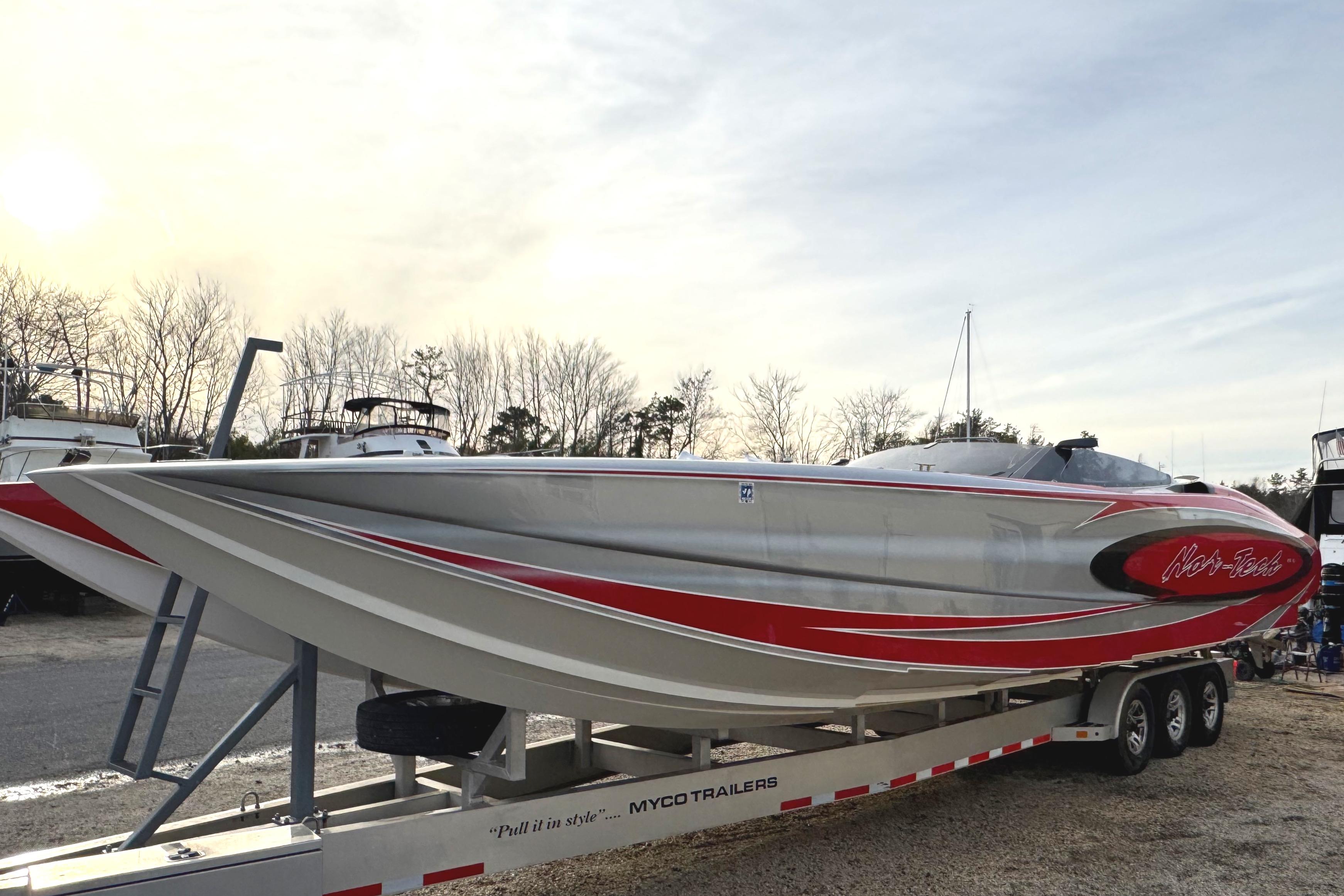 2010 Nor-Tech 4000 Roadster boat on trailer, featuring sleek red and silver design.