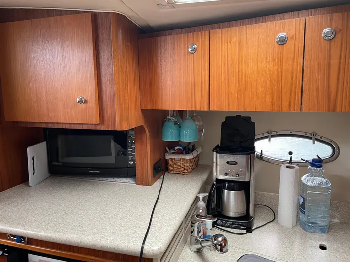  Yacht Photos Pics 2003 Tiara Yachts 3500 Open galley with wooden cabinets, microwave, and coffee maker.