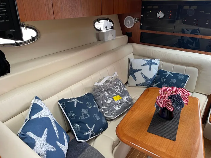  Yacht Photos Pics 2003 Tiara Yachts 3500 Open interior with starfish-themed cushions and wooden table.