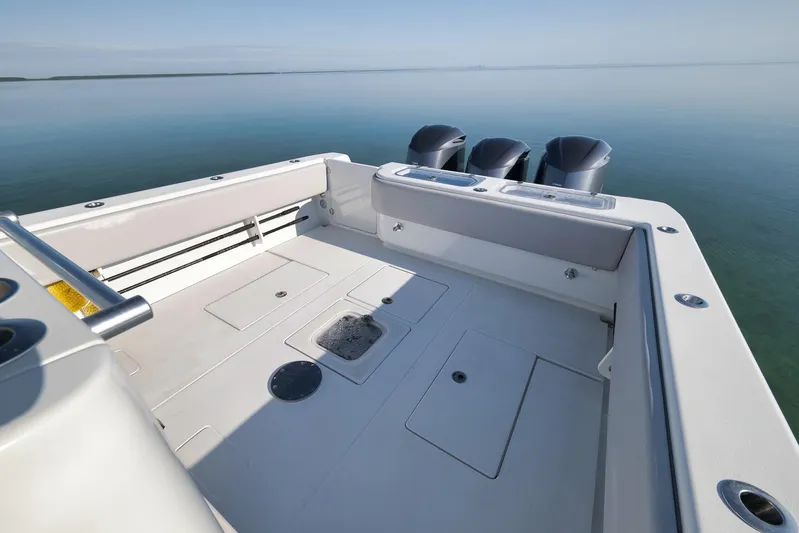  Yacht Photos Pics 2021 Contender 39 ST boat deck with triple outboard motors on calm water.