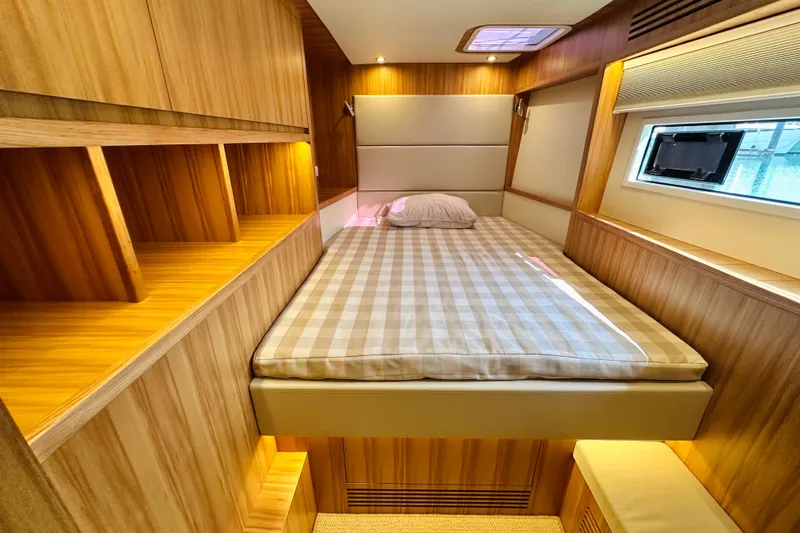  Yacht Photos Pics Luxurious ILIAD 50 yacht cabin with wood paneling and cozy bed, 2022 model.