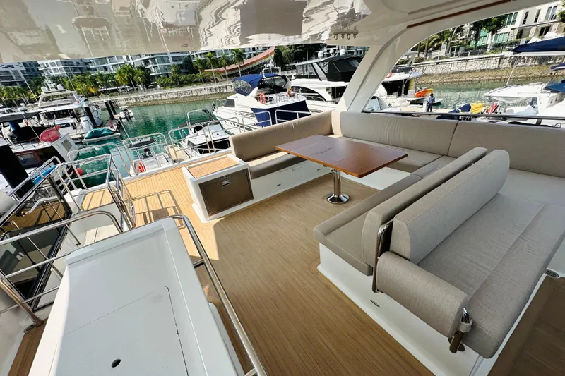  Yacht Photos Pics Luxurious ILIAD 50 yacht deck with seating, table, and marina view, 2022 model.