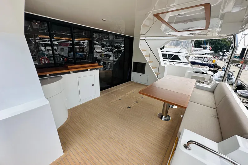  Yacht Photos Pics Spacious deck of 2022 ILIAD 50 yacht with seating, table, and marina view.