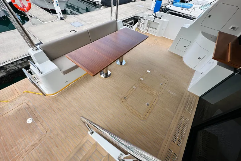  Yacht Photos Pics Luxurious ILIAD 50 yacht deck with wooden table and seating, 2022 model.