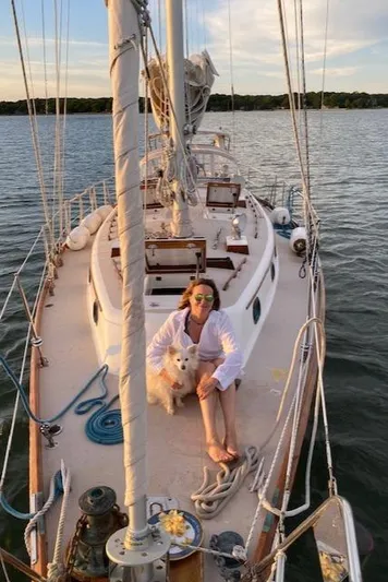 Entangled Yacht Photos Pics Person and dog relaxing on 1988 Shannon 43 sailboat deck at sunset.