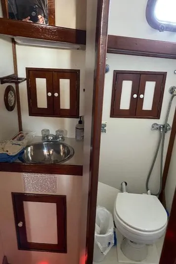 Entangled Yacht Photos Pics 1988 Shannon 43 yacht bathroom with sink, toilet, and wooden cabinets.