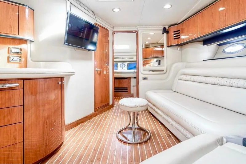 Nauti Nauti Yacht Photos Pics Luxurious interior of 2000 Sea Ray 450 Express Bridge yacht with wood accents and modern amenities.