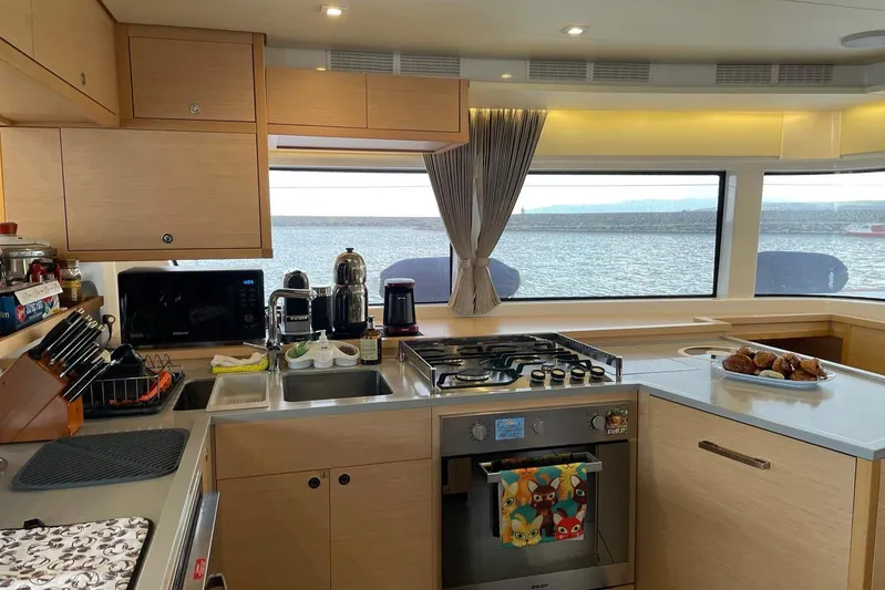Chicago Yacht Photos Pics Modern kitchen interior on 2020 Lagoon 52 F yacht with sea view through large windows.