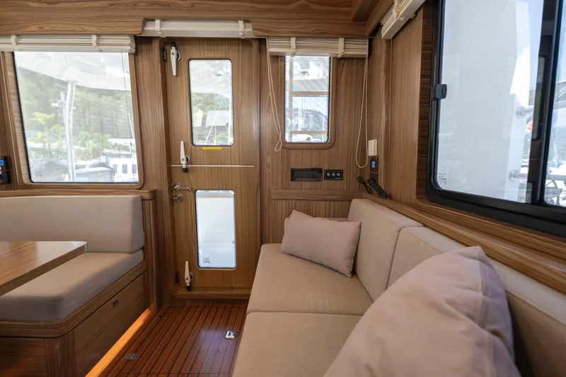  Yacht Photos Pics Interior of 2024 Nordhavn 41 yacht, featuring wood paneling and comfortable seating.