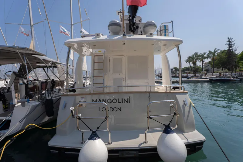  Yacht Photos Pics 2024 Nordhavn 41 yacht docked in a marina, surrounded by sailboats and palm trees.