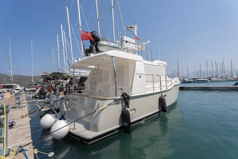  Yacht Photos Pics 2024 Nordhavn 41 yacht docked at marina, surrounded by sailboats under clear sky.