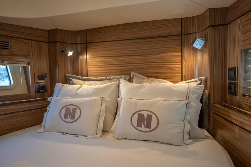  Yacht Photos Pics Luxurious cabin interior of 2024 Nordhavn 41 yacht with elegant wood paneling and plush bedding.