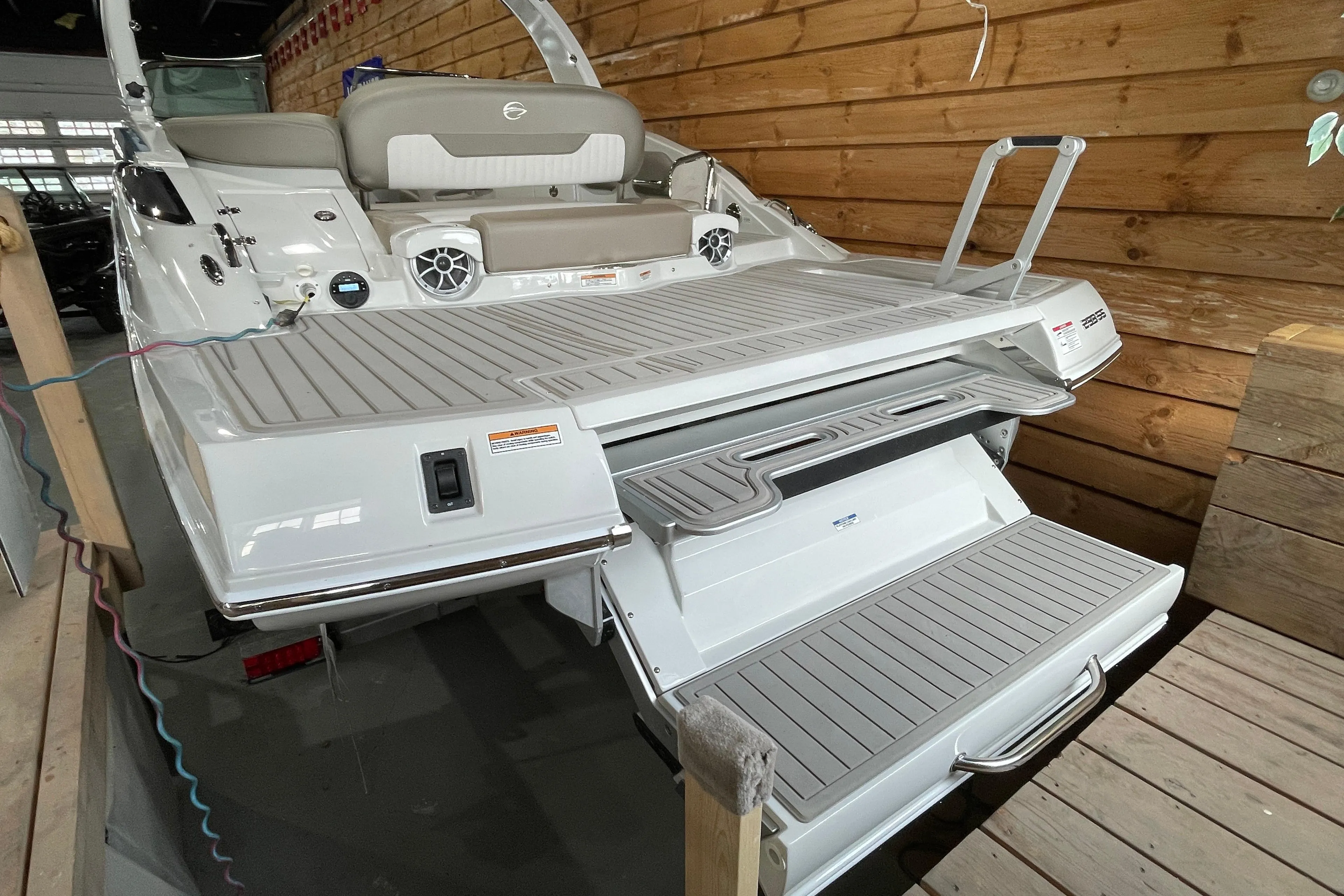 2026 Crownline 298 SS boat with extended swim platform and seating, displayed indoors.