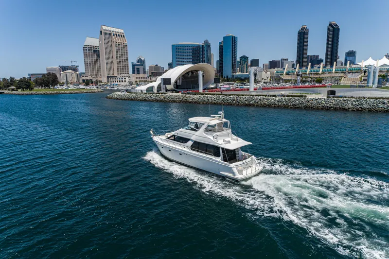 All Falked Up Yacht Photos Pics 1999 Carver 530 Voyager Pilothouse yacht cruising near city skyline.