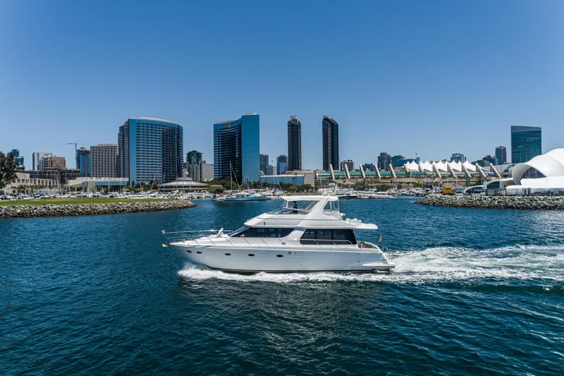 All Falked Up Yacht Photos Pics 1999 Carver 530 Voyager Pilothouse yacht cruising near city skyline.