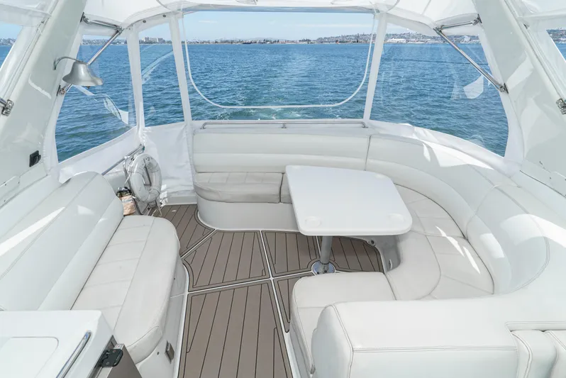 All Falked Up Yacht Photos Pics 1999 Carver 530 Voyager Pilothouse interior with white seating and table, overlooking the ocean.