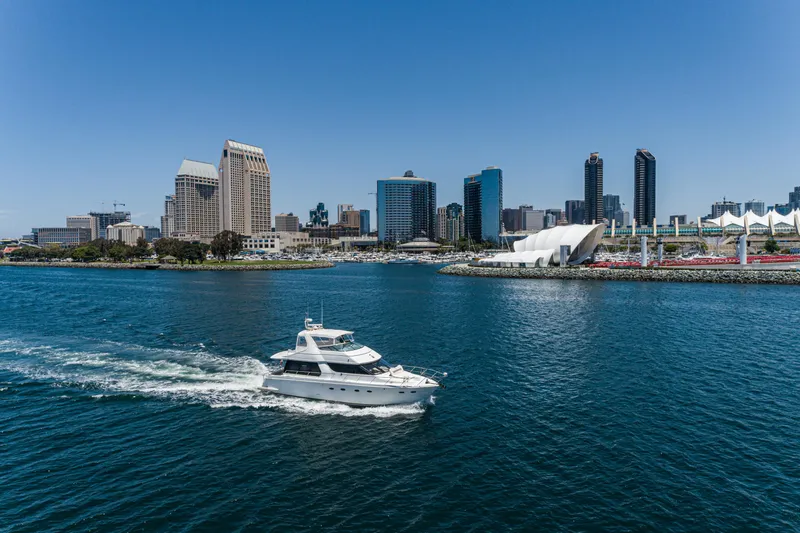 All Falked Up Yacht Photos Pics 1999 Carver 530 Voyager Pilothouse yacht cruising near city skyline and waterfront.