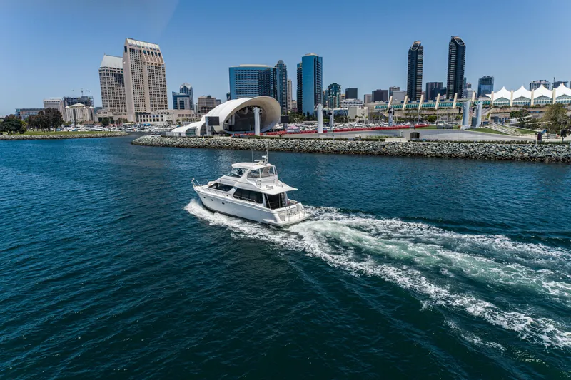 All Falked Up Yacht Photos Pics 1999 Carver 530 Voyager Pilothouse yacht cruising near city skyline and waterfront.