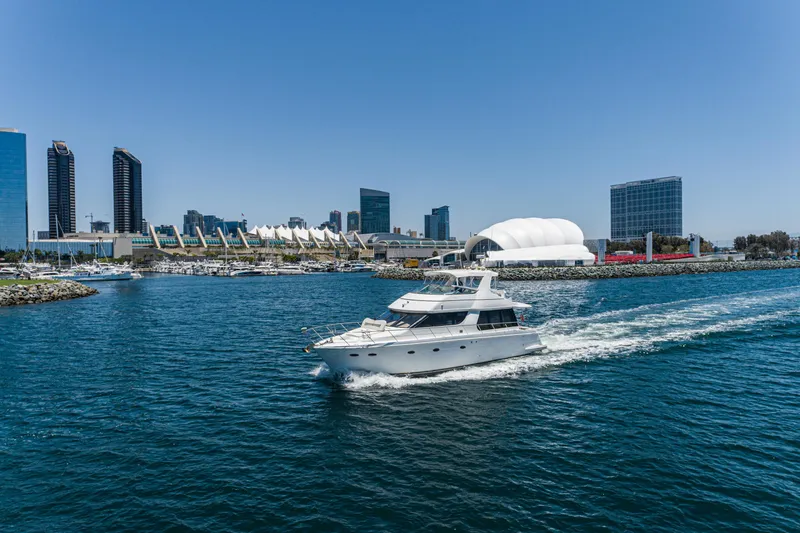 All Falked Up Yacht Photos Pics 1999 Carver 530 Voyager Pilothouse yacht cruising near city skyline.