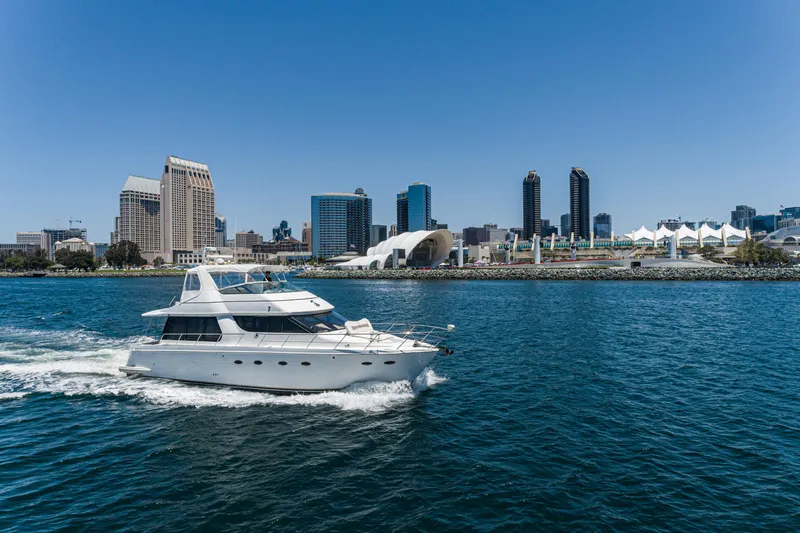 All Falked Up Yacht Photos Pics 1999 Carver 530 Voyager Pilothouse yacht cruising near city skyline.