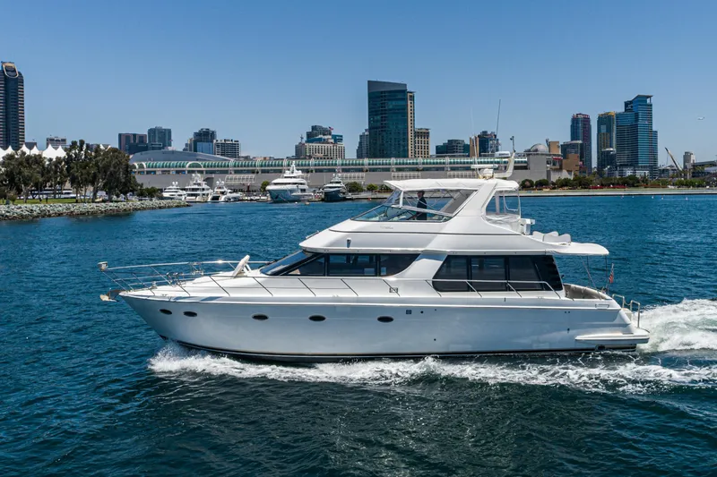 All Falked Up Yacht Photos Pics 1999 Carver 530 Voyager Pilothouse yacht cruising near city skyline.