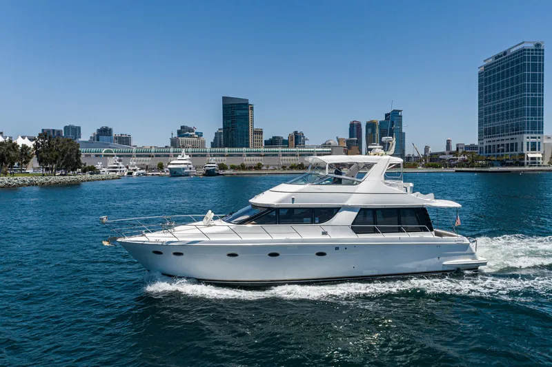 All Falked Up Yacht Photos Pics 1999 Carver 530 Voyager Pilothouse yacht cruising near city skyline.