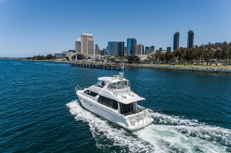All Falked Up Yacht Photos Pics 1999 Carver 530 Voyager Pilothouse yacht cruising near city skyline.