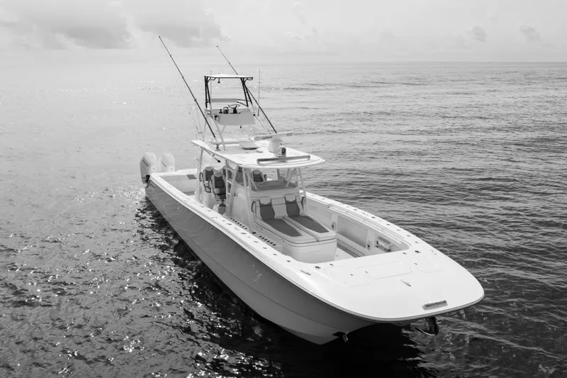 Seeking Twin Tales Yacht Photos Pics 2022 Invincible 46 Catamaran on calm ocean waters, showcasing sleek design and fishing equipment.