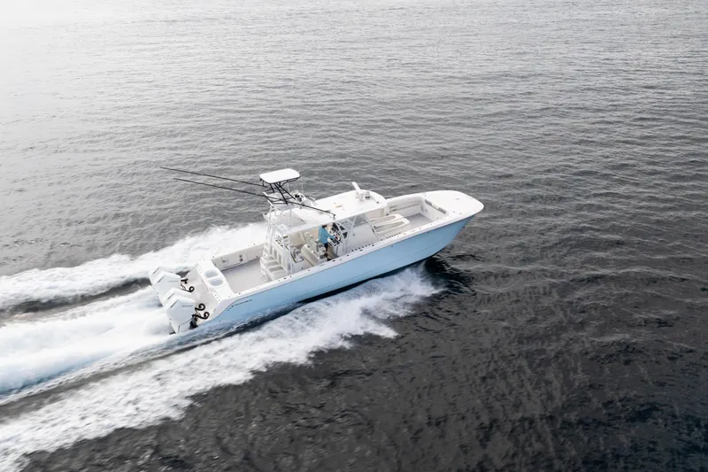 Seeking Twin Tales Yacht Photos Pics 2022 Invincible 46 Catamaran cruising on open water, showcasing sleek design and powerful engines.